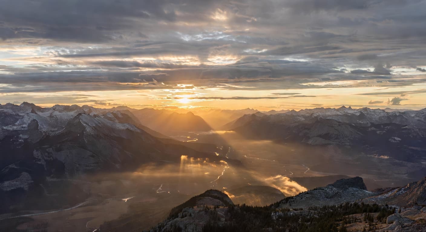 Amanecer dorado sobre montañas con nubes iluminadas por la primera luz del día